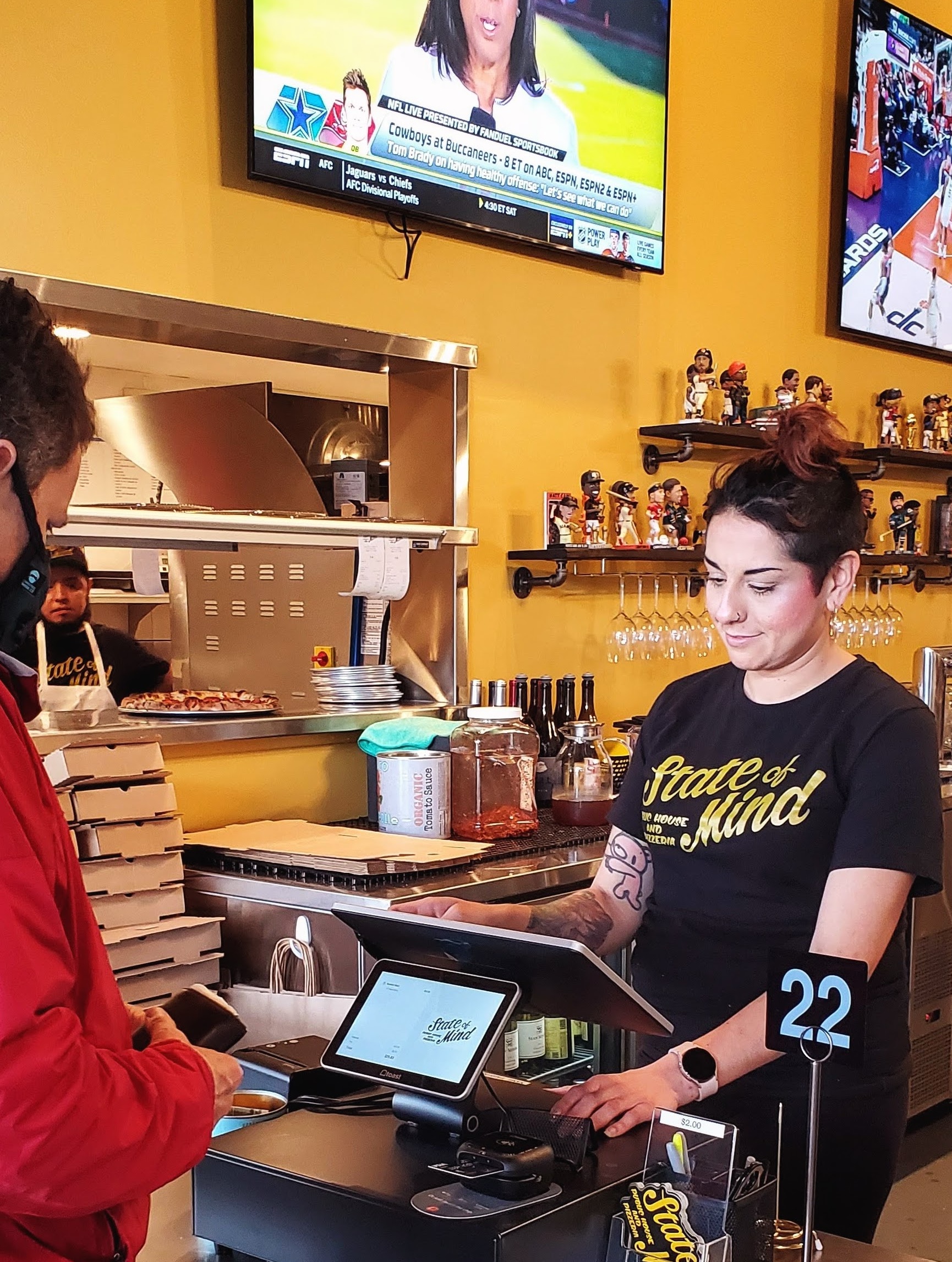 A cashier at State of Mind helping out a customer.