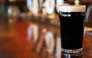 A glass of beer on a counter.