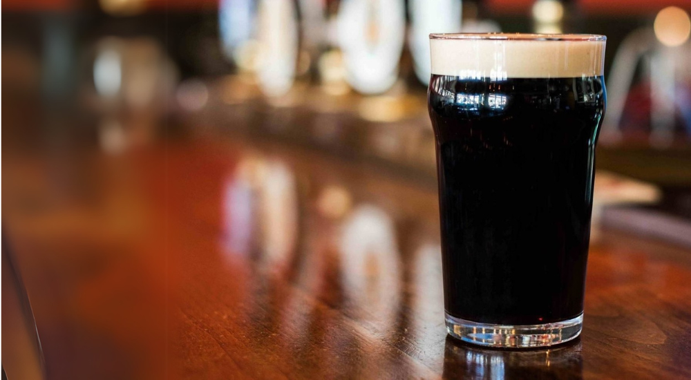 A glass of beer on a counter.