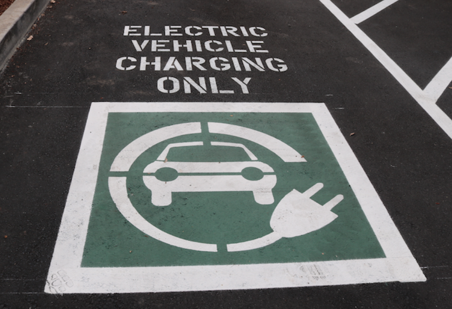 A parking spot with graphic on the pavement marking it as "Electric vehicle charging only."