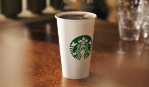 A paper coffee cup with the Starbucks logo on it.