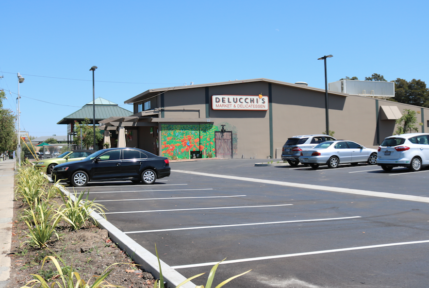 A wide shot of the West Parking Lot, with Delucchi's Market in the distance.